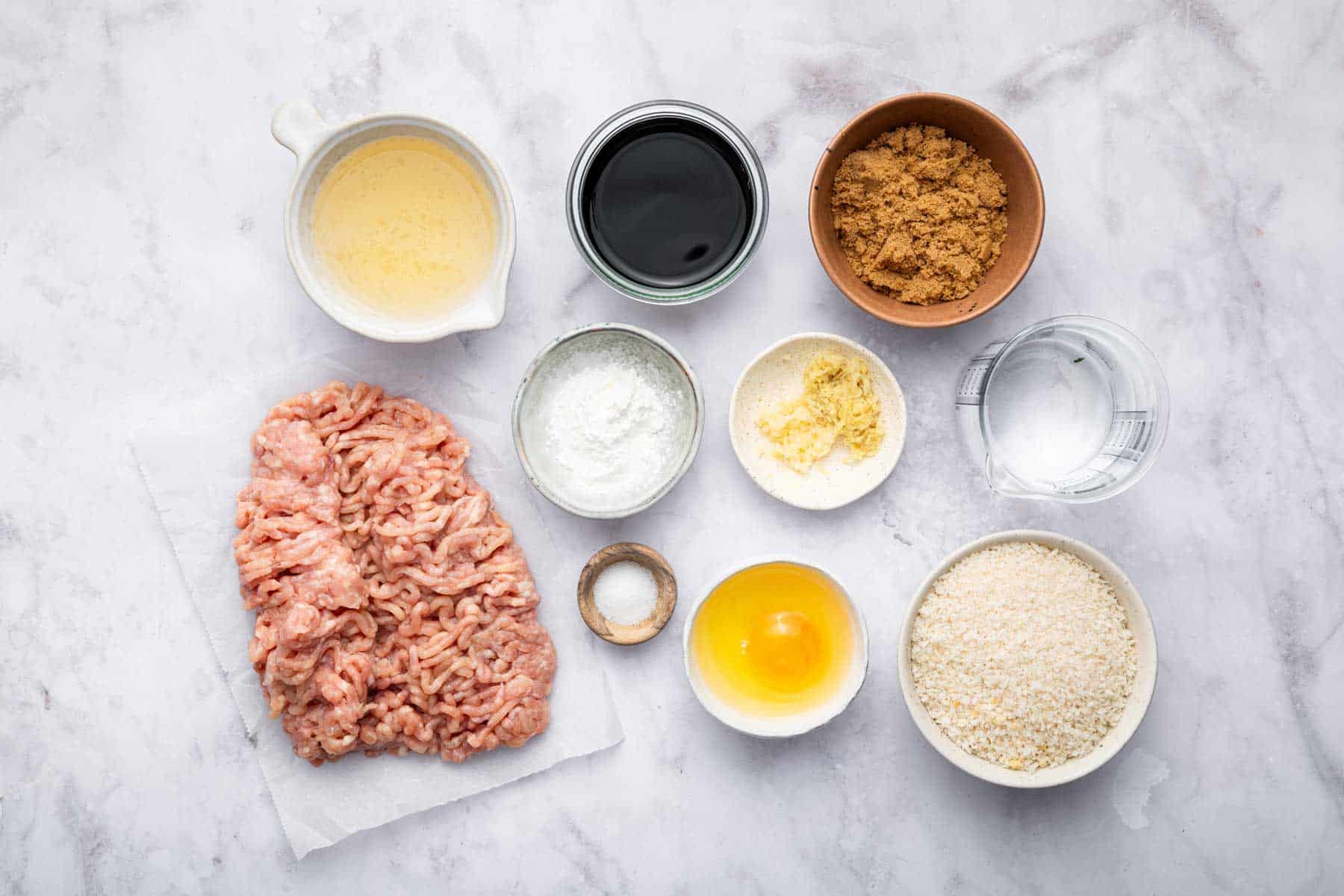 Little bowls with ground meat, brown sauces, panko bread crumbs, and an egg.