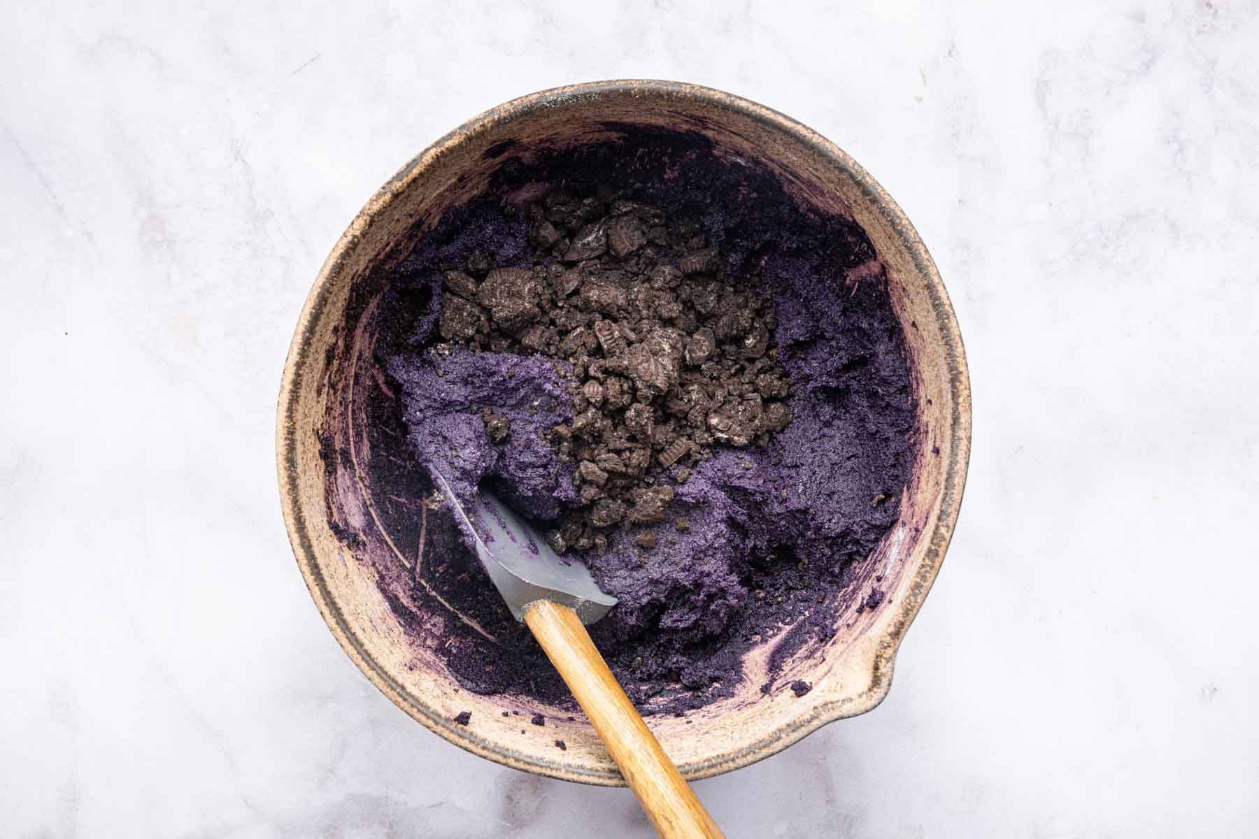 Dark purple dough with crushed Oreos on top.