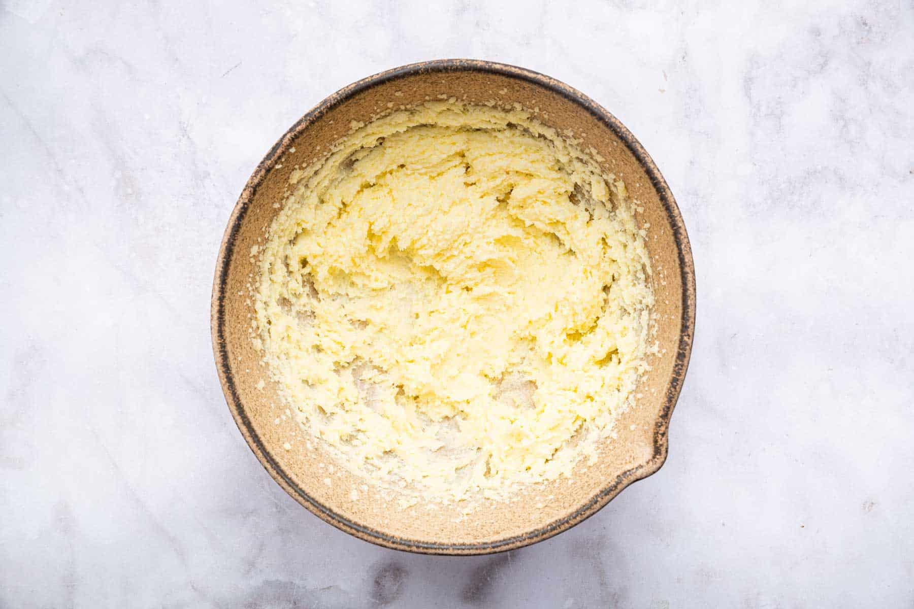 Brown bowl with butter smeared all inside of it.
