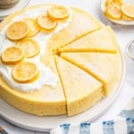 Round yellow yogurt cake recipe on plate with lemon slices on top.
