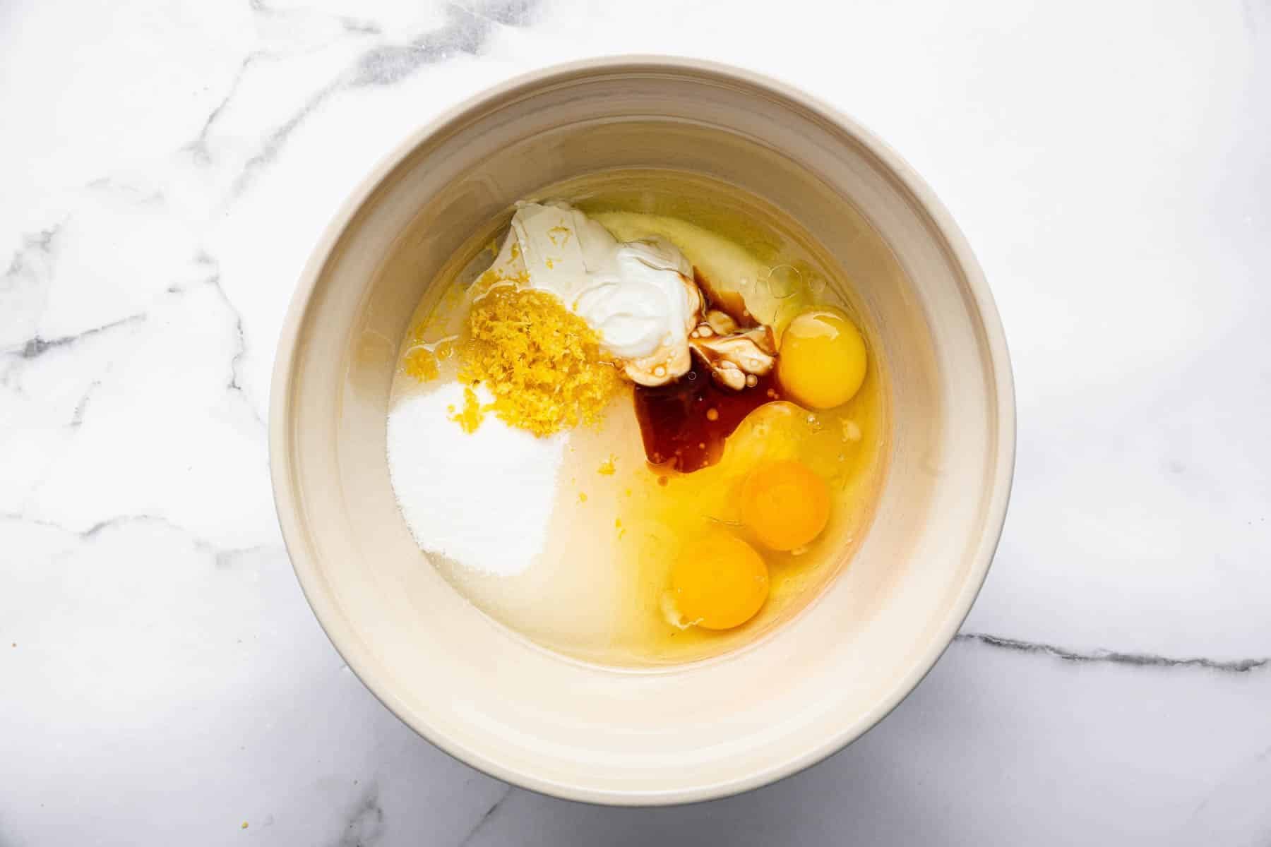 Bowl with sugar, lemon zest, and large eggs.